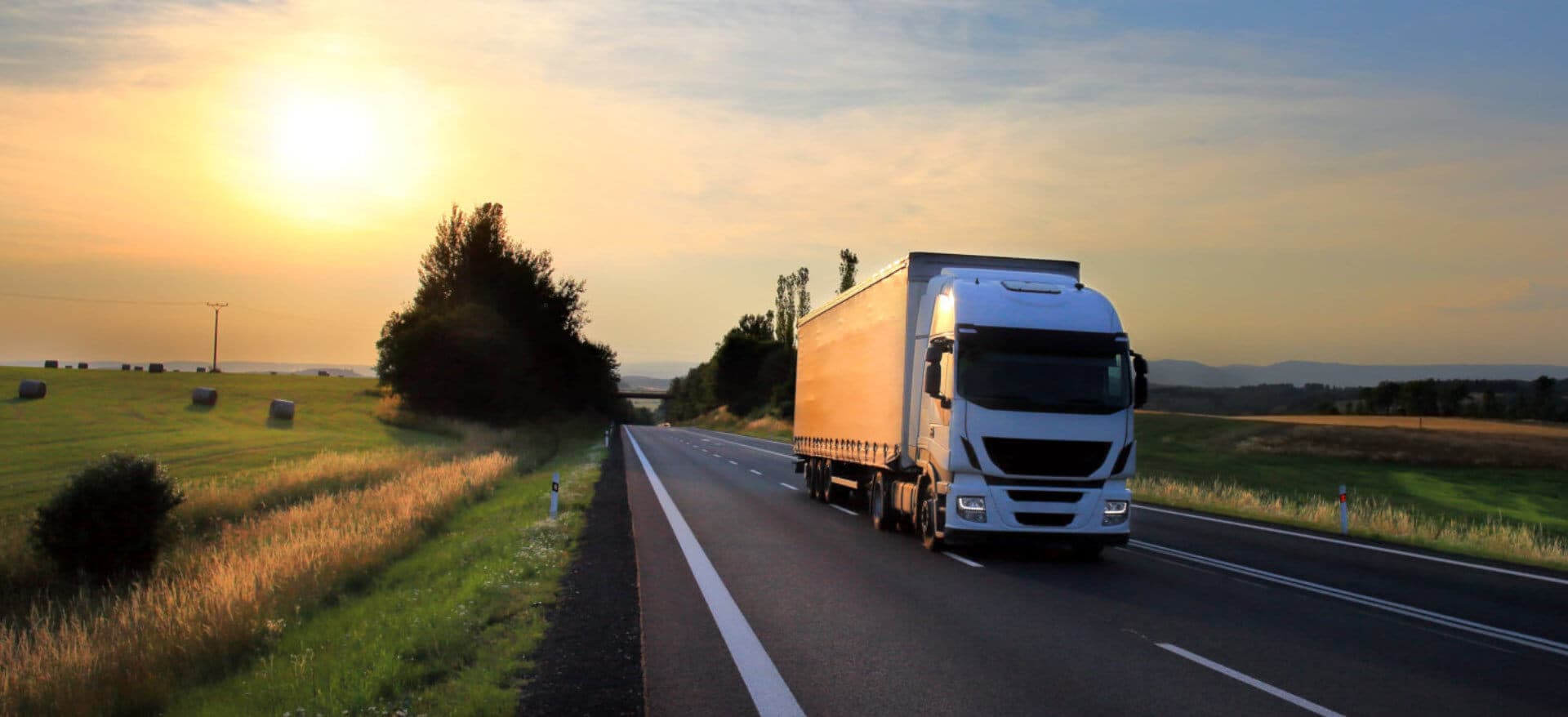 white truck running while the sun is setting down