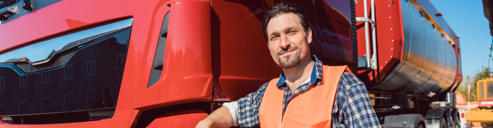 a driver smiling for the camera outside of the truck